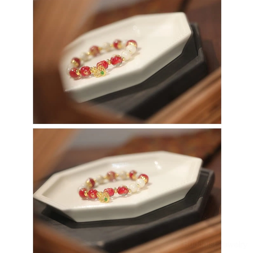 Compact red and gold beaded bracelet with intricate bead pattern displayed on octagonal white tray