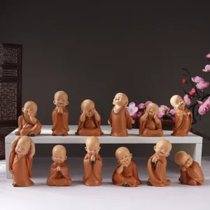 Assorted mini meditation monk resin figurines collection in terracotta, displaying multiple poses for Buddhist home decor and spiritual altar