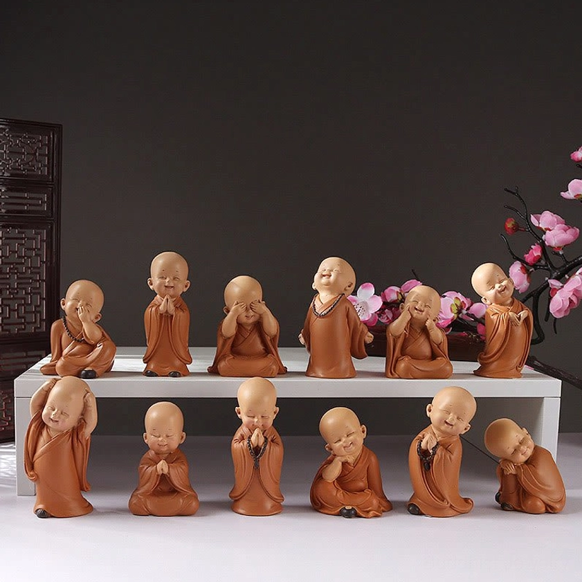 Assorted mini meditation monk resin figurines collection in terracotta, displaying multiple poses for Buddhist home decor and spiritual altar