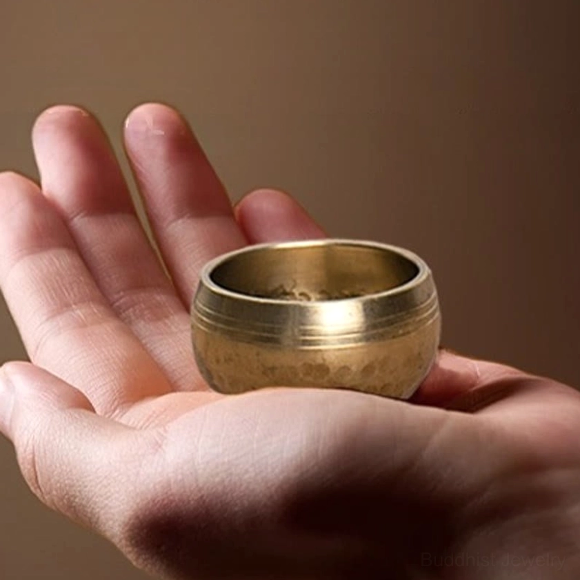 Portable Buddhist singing bowl fitting in adult palm showing compact size perfect for travel meditation