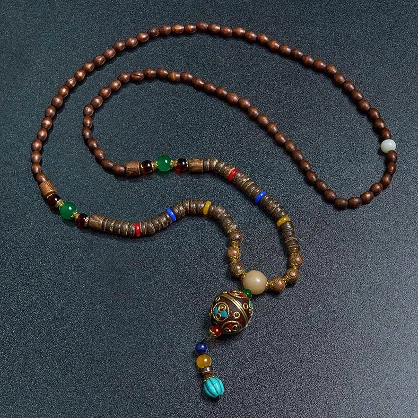 Minimalist Buddhist meditation necklace with brown wooden beads and metal stone accents flat lay