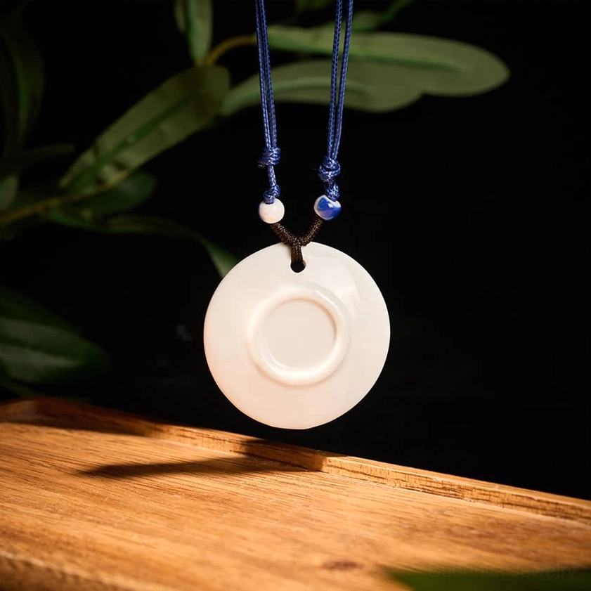 Misty river boat scenery ceramic pendant necklace frontal view showing artistic landscape painting