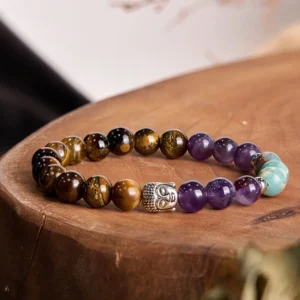 Mixed gemstone Buddha head bracelet with tiger eye, amethyst, green aventurine beads and silver Buddha charm in flat lay