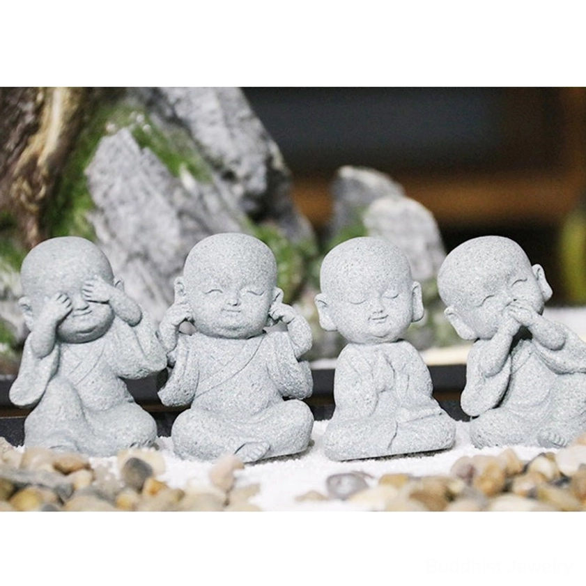 Closeup detail of handcrafted monk Buddha statue showing natural sandstone texture and matte finish