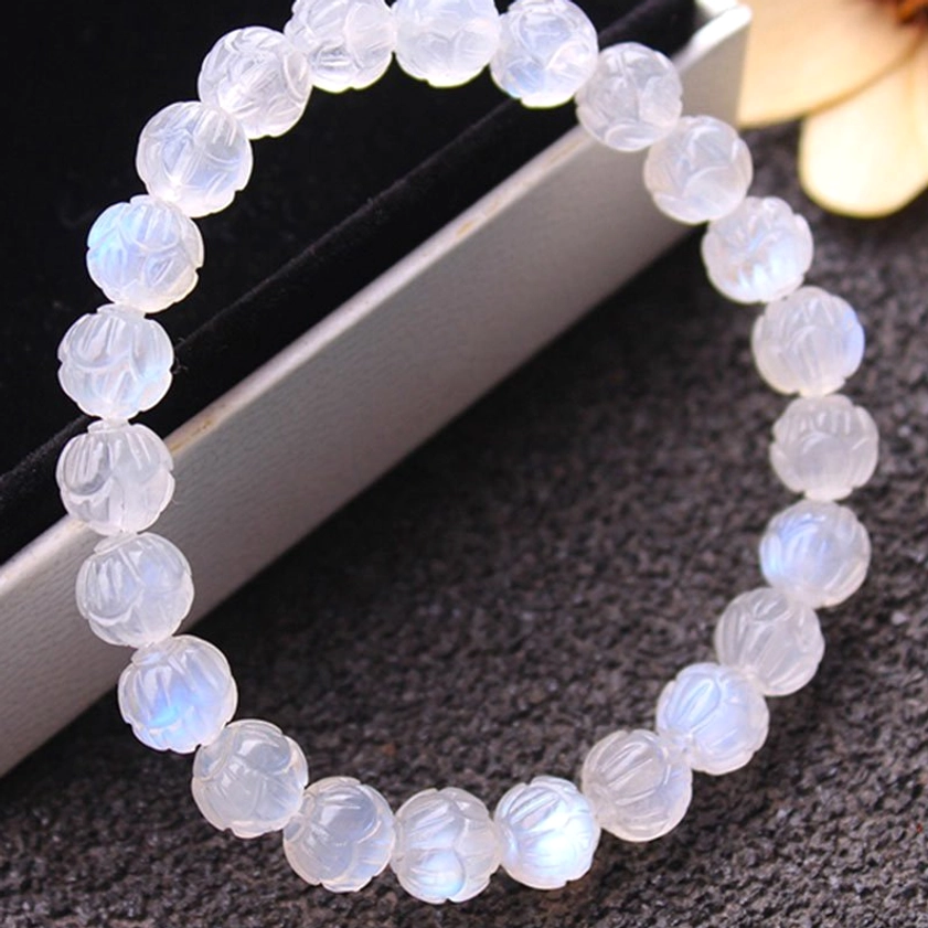 Moonstone lotus carved bracelet side view showing clear blue schiller effect and detailed lotus carving on beads