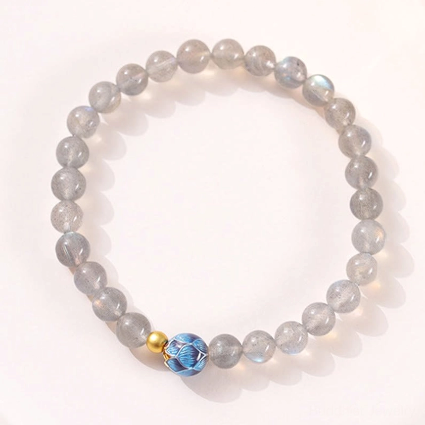 Complete moonstone lotus Buddhist bracelet flat lay showing full strung beads with iridescent gray moonstone, blue lotus charm and gold accents