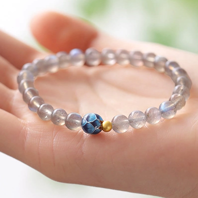 Moonstone lotus bracelet held in palm against soft natural light background showing bead size and intricate details
