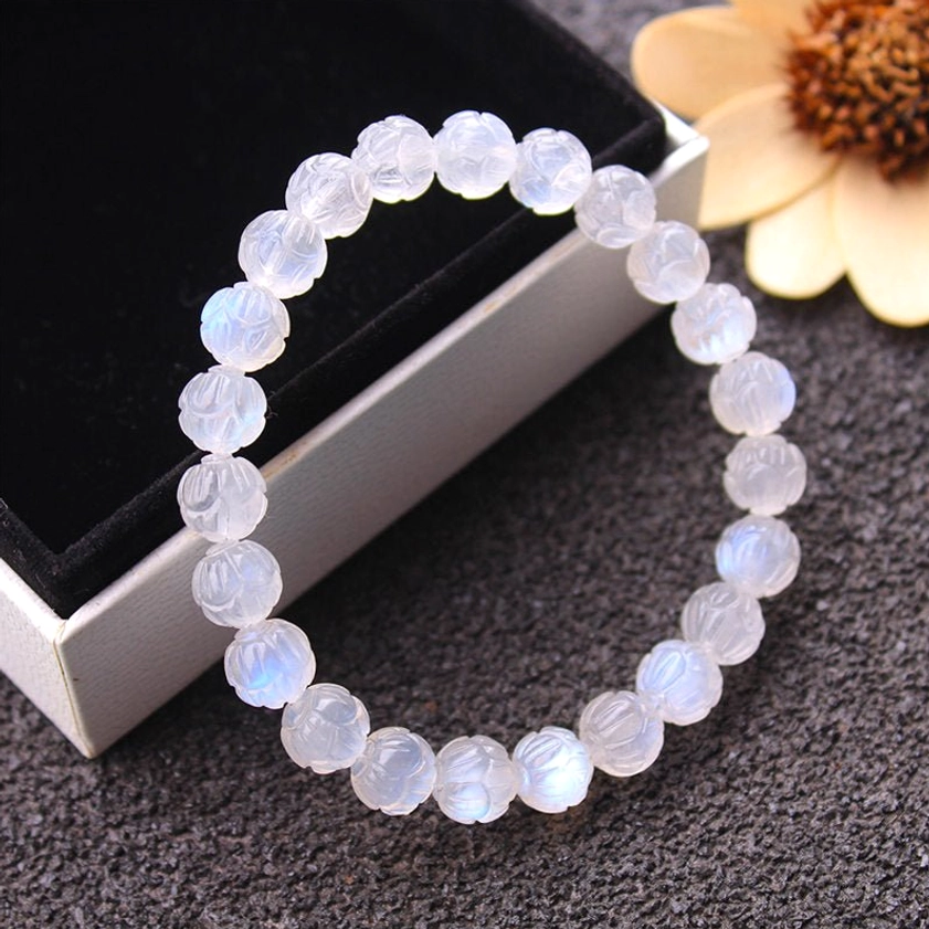Moonstone lotus beaded bracelet side view in elegant jewelry box, milky white translucent finish with carved lotus detail