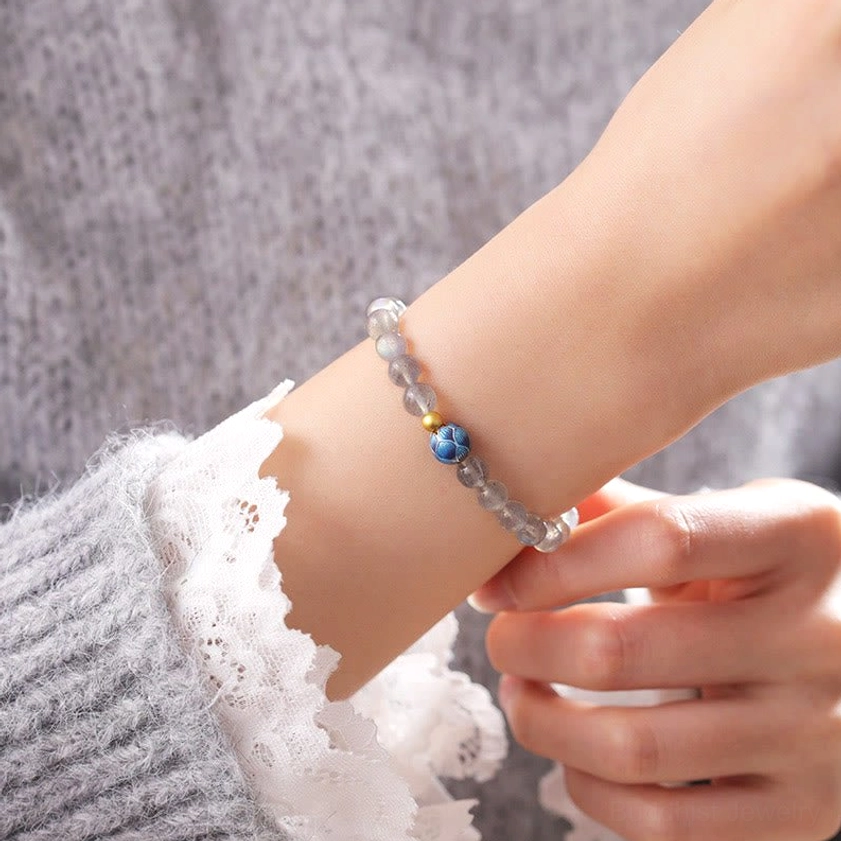 Moonstone lotus bracelet worn on wrist with knitted sweater and lace cuff, lifestyle wearing demonstration