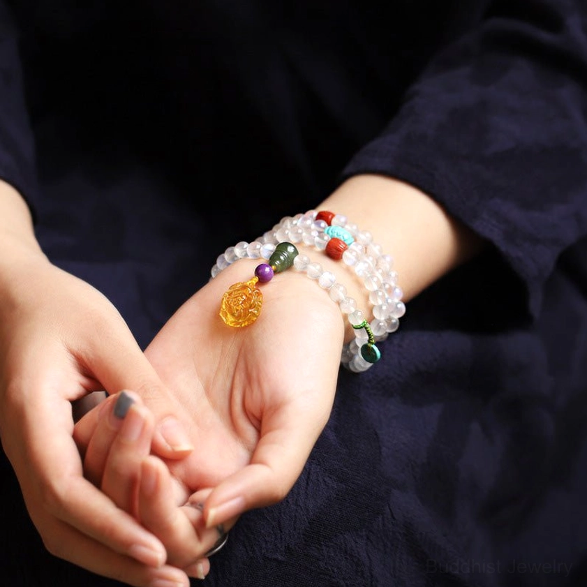 Multi-loop moonstone mala bracelets worn on human wrists, close-up view with gemstone decorations