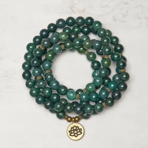 Moss agate 108 bead Buddhist prayer mala flat lay with gold lotus charm pendant, round green marbled agate beads with gold spacers on neutral background