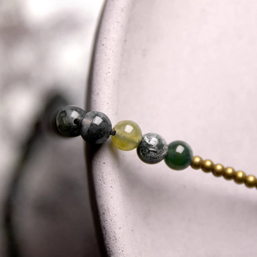 Moss agate beaded bracelet strand close-up detail shot showing natural stone texture and gold copper beads