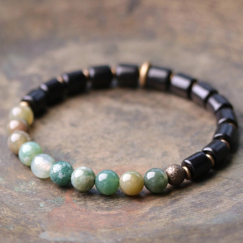 Moss agate and ebony wood Buddhist bracelet flat lay showing mixed cylindrical and round beads with copper accents