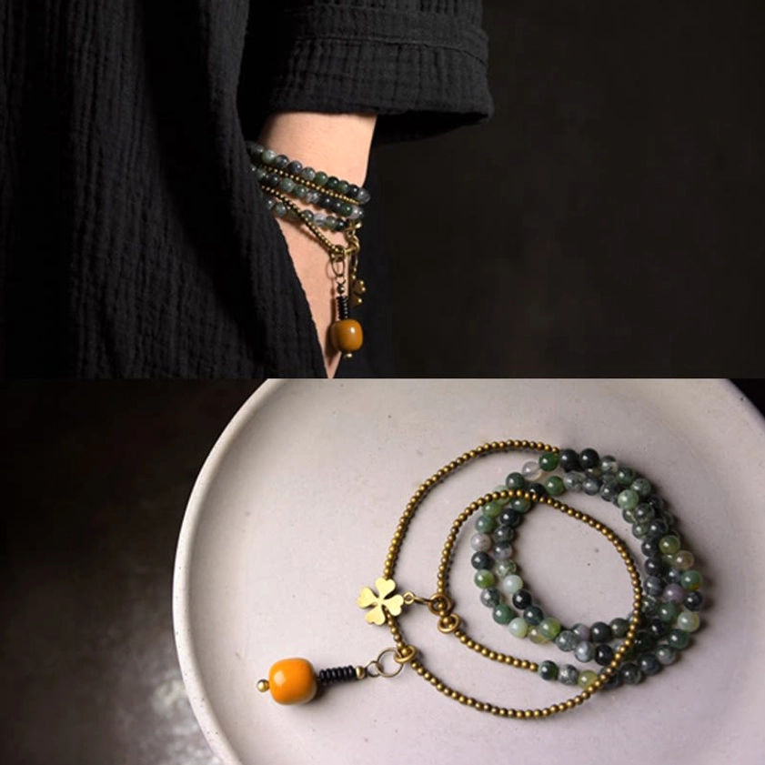 Slim moss agate bead bracelet layers with hanging decorative pendant worn as wrist stack