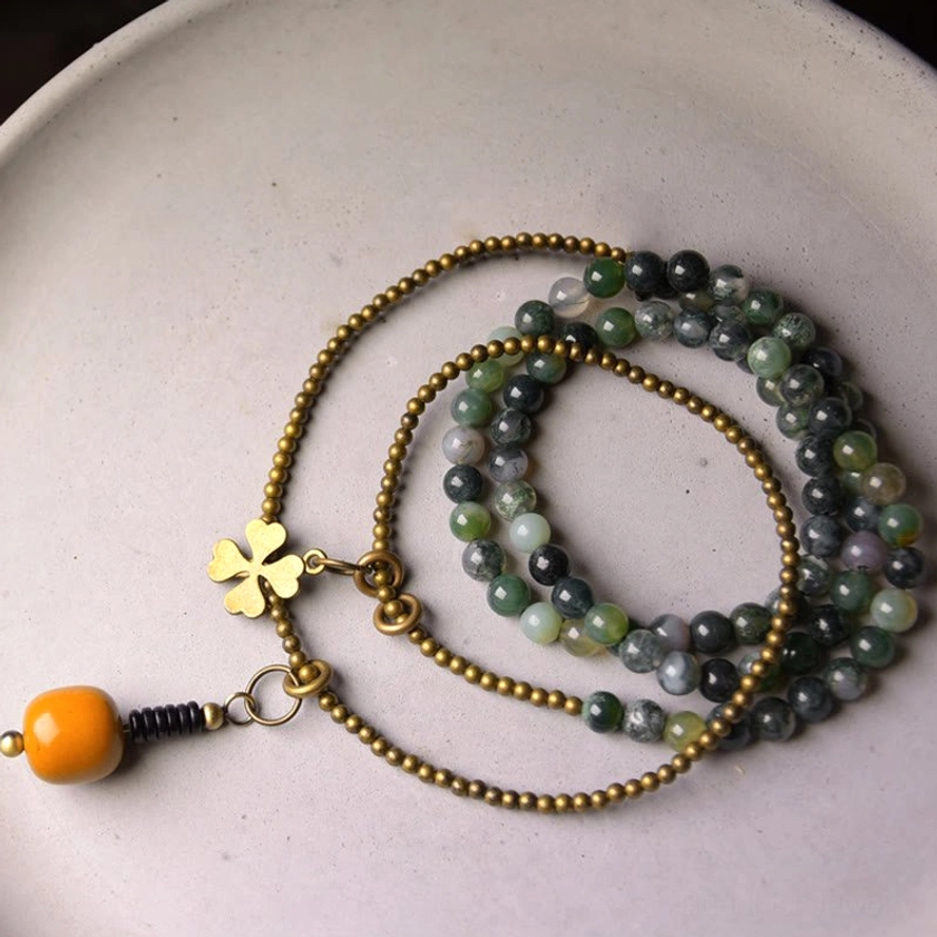 Multilayer moss agate beaded bracelet flat lay overhead view with brass chains and natural stone beads