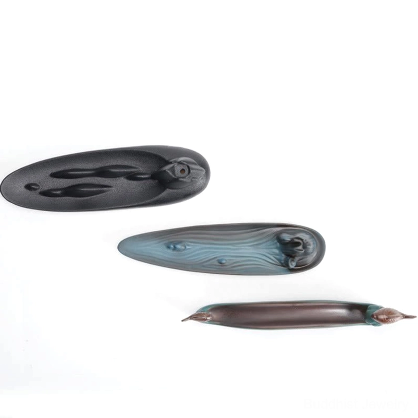 Mountain incense burner detail with fisherman figurine and incense holder slot