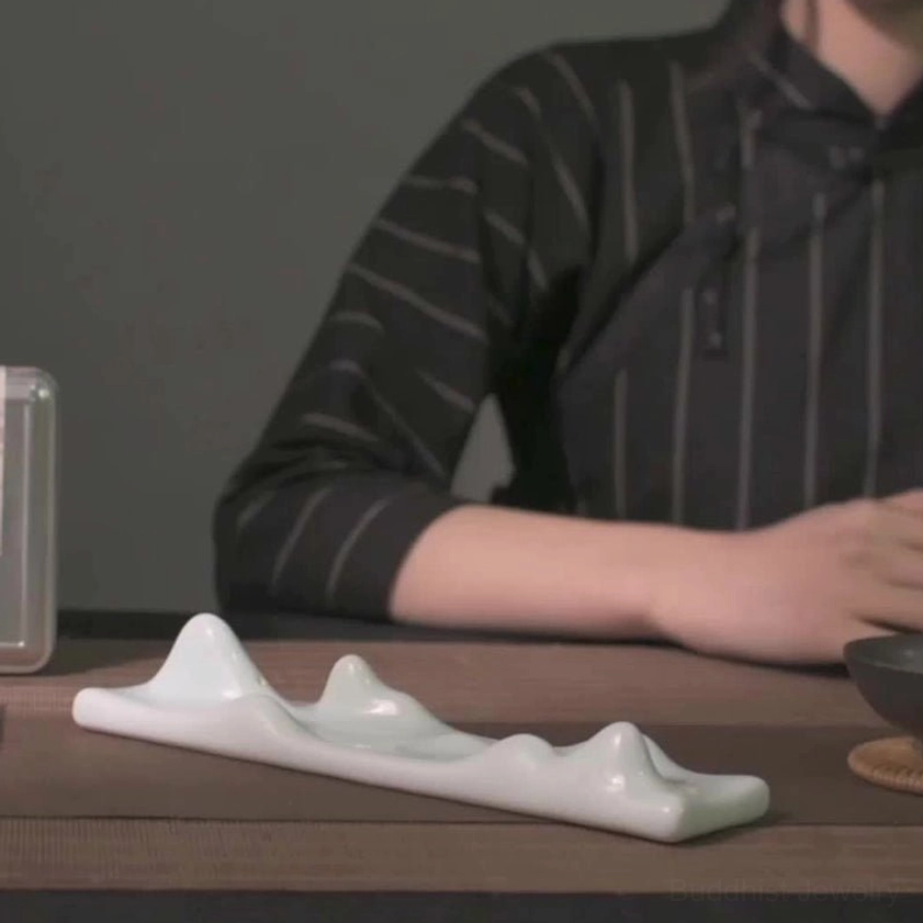 Mountain peak incense holder displayed on wooden tea table in interior meditation space