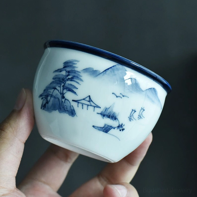 Handcrafted ceramic teacup with traditional mountain and pine tree landscape design