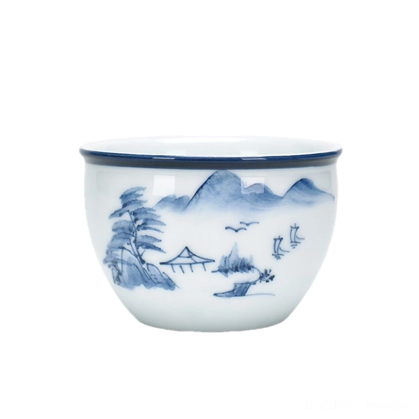 Blue and white ceramic tea cup featuring mountain tree house landscape painting