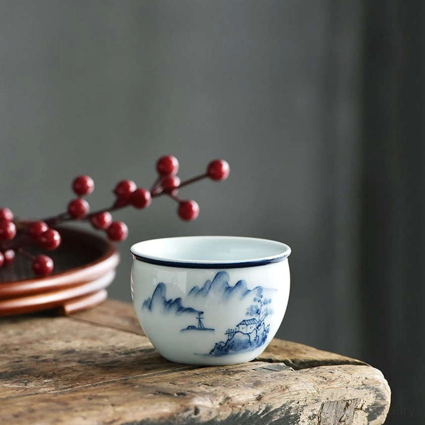 Ceramic tea cup with mountains and trees landscape pattern, hand-painted blue-and-white porcelain