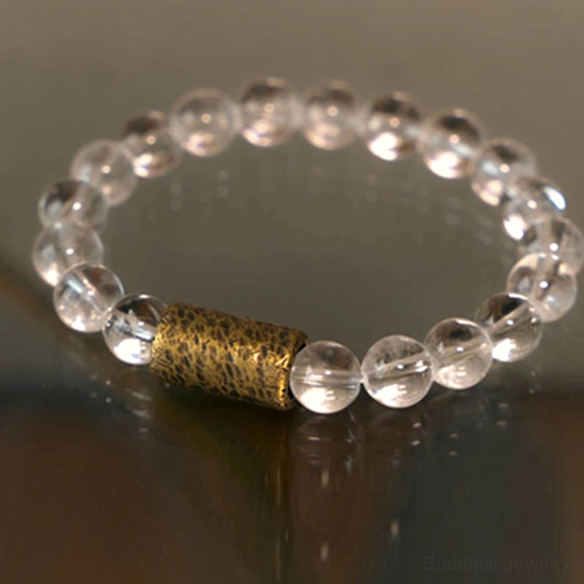 Clear quartz purple phantom protection bracelet close-up on wooden surface showing bead detail and bronze spacer