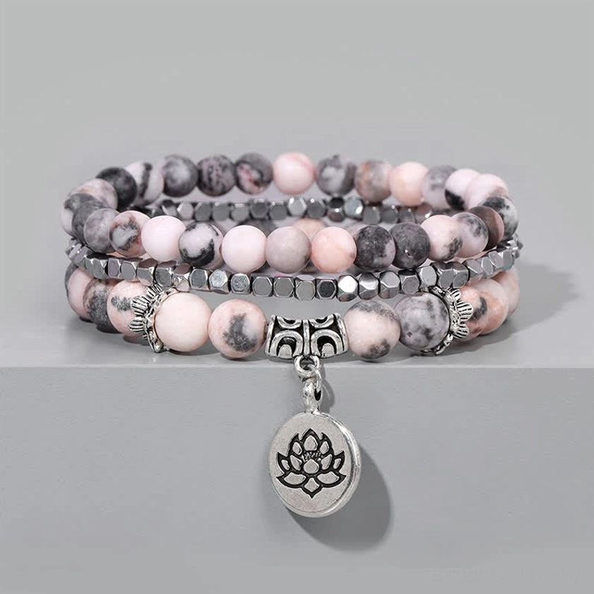 Multi-strand beaded bracelet with silver lotus charm flat lay gray background