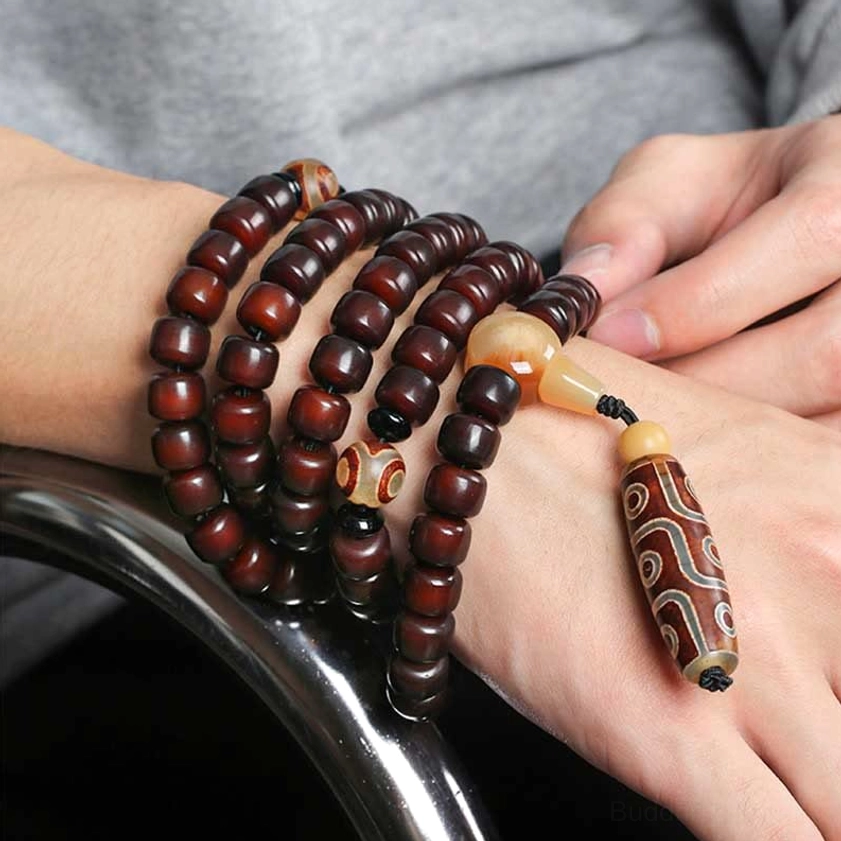 Multi-wrap dzi mala bracelet worn on hands showing adjustable wrist circumference, protective stone amulet design for Buddhist prayer practice