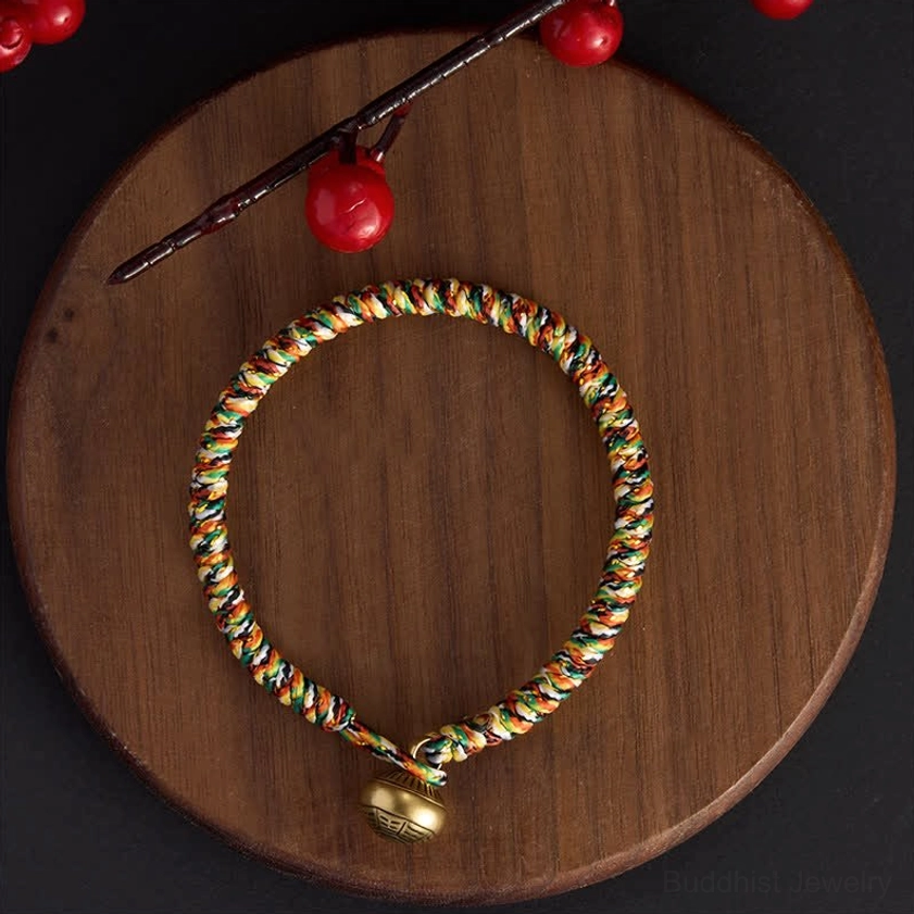Simple multicolor braided Buddhist balance bracelet with tight twisted weave and brass charm pendant