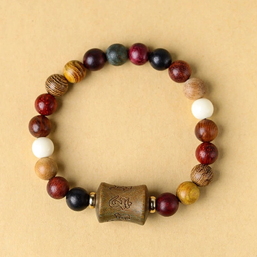 Single multicolor sandalwood bracelet flat lay, featuring intricately carved focal bead and natural wood beads