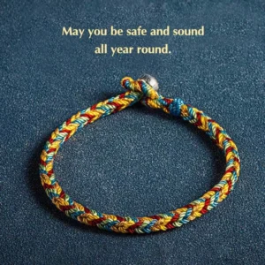 Handwoven multicolored Buddhist protection bracelet with sterling silver charm, close-up detail showing braided rope texture and metal clasp on dark background