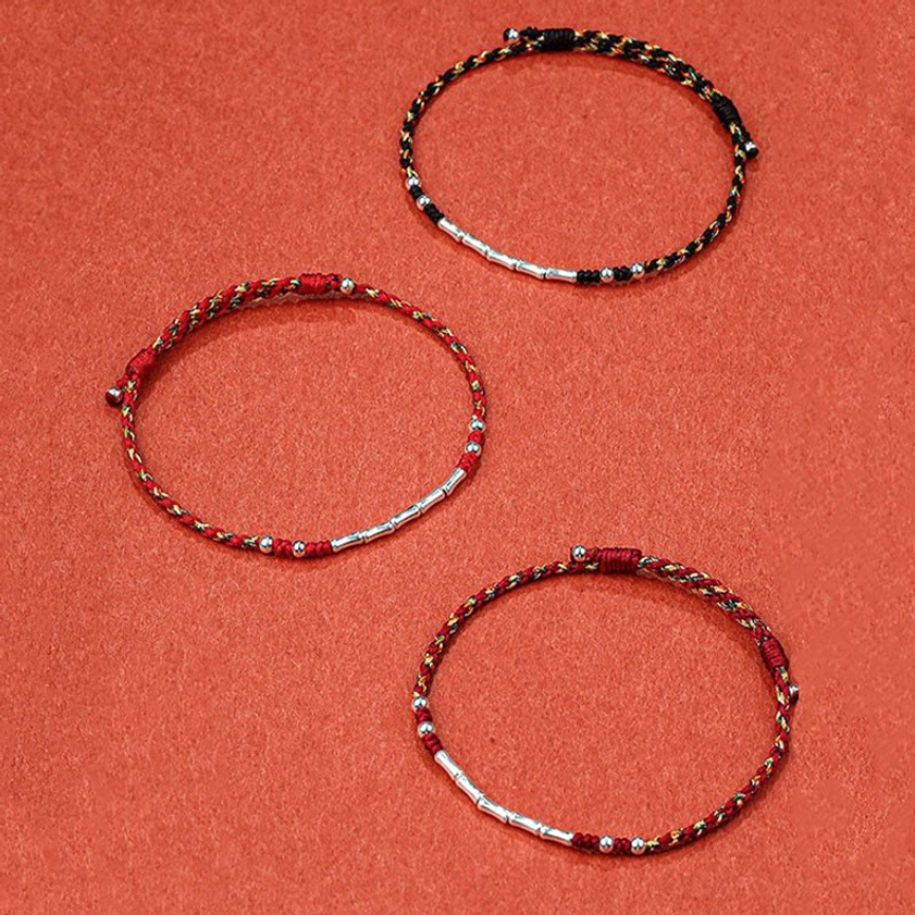 Multiple handmade Buddhist string bracelets in different color variations displayed flat lay