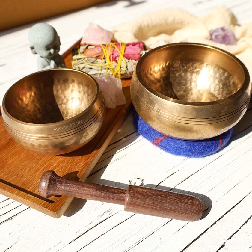 Two handcrafted Buddhist singing bowls with engraved wooden mallet on wooden tray, showcasing multiple bowl sizes for different meditation and sound therapy needs