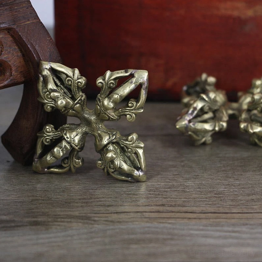 Three copper vajra dorje pieces arranged overhead high angle view with antique brass metal and detailed carved prongs