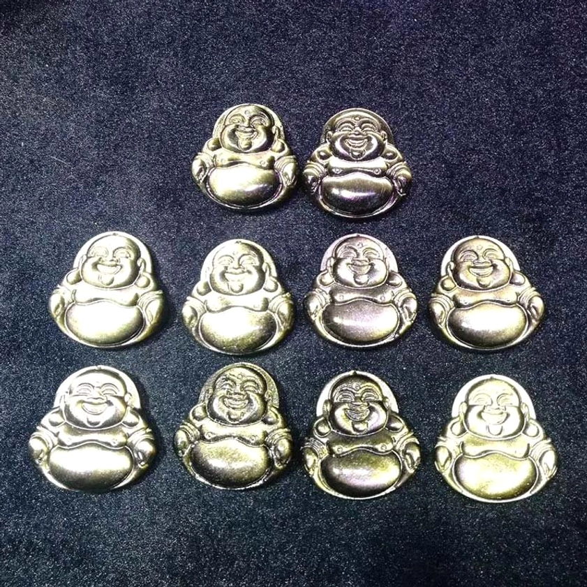 Collection of ten identical hand-carved laughing Buddha obsidian pendants with golden sheen displayed on dark background