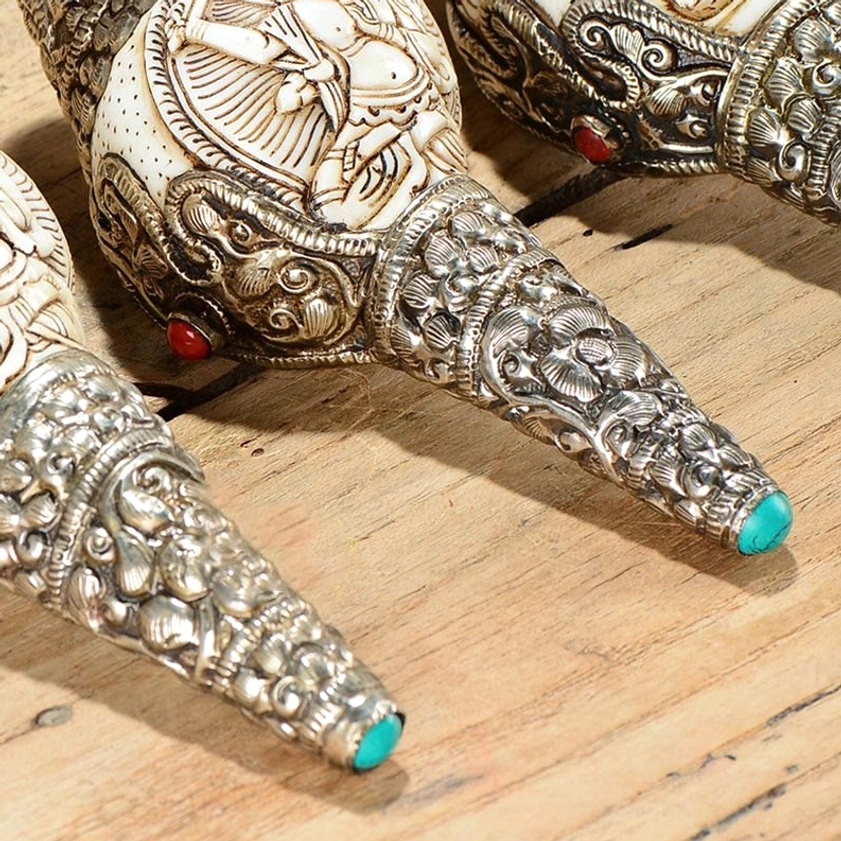 Group of hand-carved shankha conch ornaments with multiple silver-wrapped designs