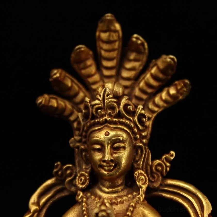 Head and upper torso close-up of Nagarjuna Buddha statue with beaded necklaces and detailed cobra headdress