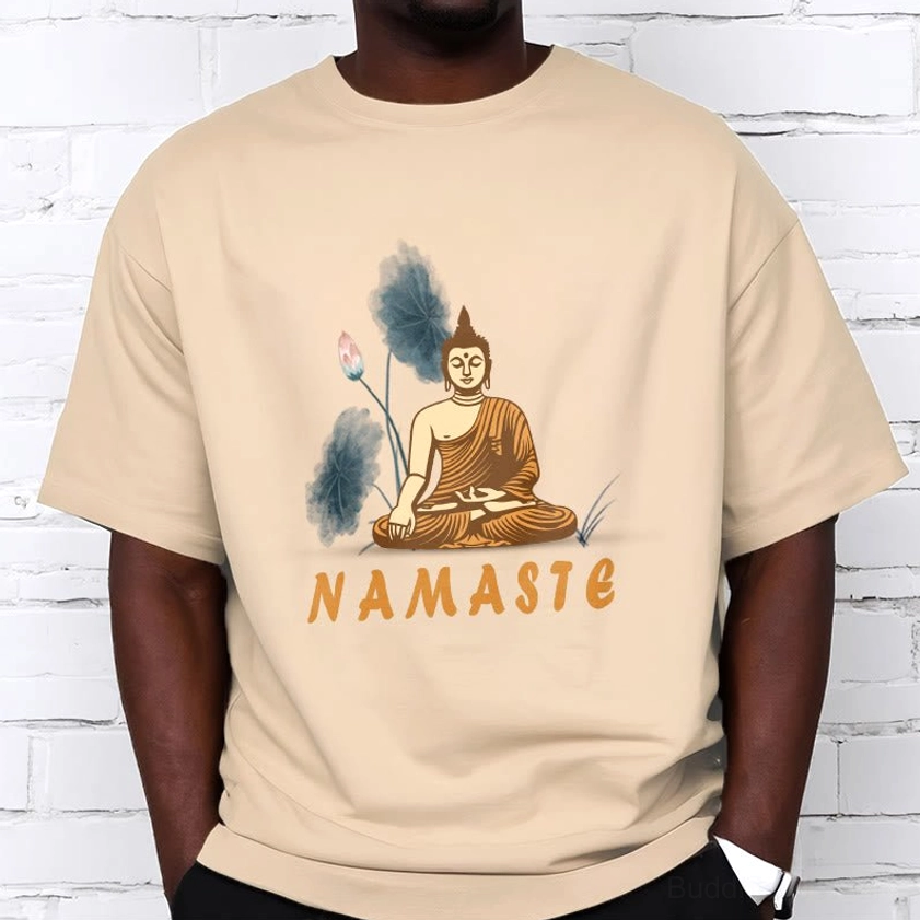 Male model wearing Namaste Buddha Lotus mindfulness T-Shirt in beige against white brick wall for casual street style