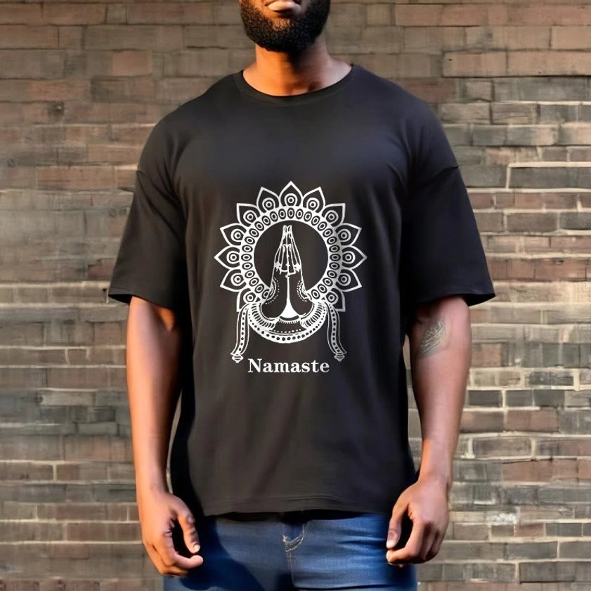 Full front view of male model wearing black Namaste mandala prayer hands Buddhist tee against outdoor brick wall background