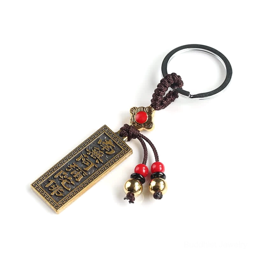 Three-quarter front view of Namo Amitabha keychain with sutra text bronze tag and red enamel decoration on white background