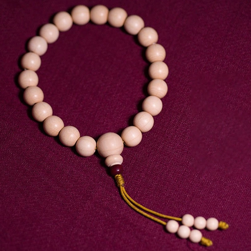 Natural Abelia Biflora wood mala bracelet overhead flat lay showing uniform round wooden beads