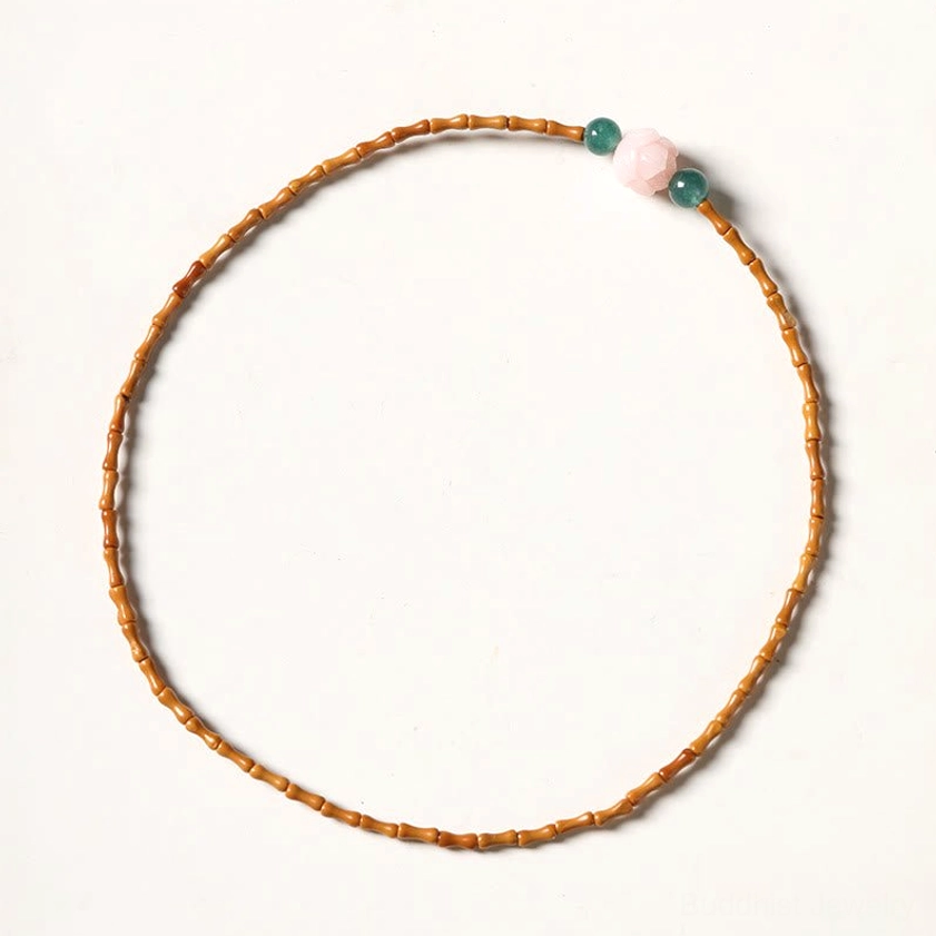 Natural olive pit jade beads and coral shell lotus bead showing texture and craftsmanship of handmade Buddhist bracelet
