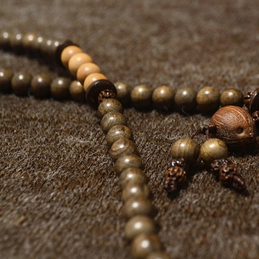 Natural sandalwood mala prayer beads bracelet with decorative tassel, representing 108 sacred beads in Buddhist tradition