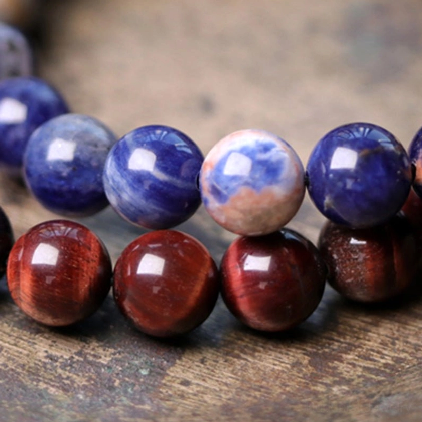 Close-up view of natural stone beads showing blue sodalite and red tiger eye crystal texture