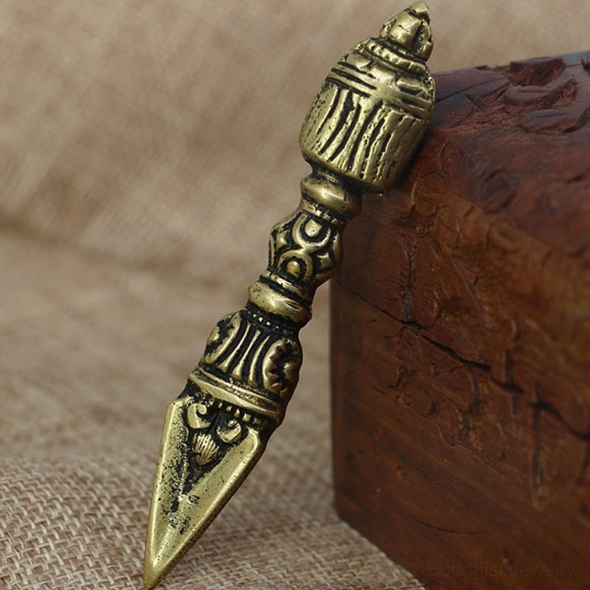 Nepalese ritual vajra dorje phurba with fierce deity head ornament and intricately carved shaft on burlap background