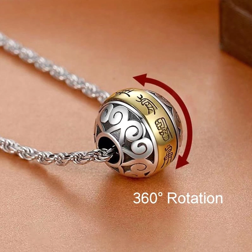 360-degree rotatable copper mantra amulet showing detailed two-tone engraving with rotation feature marked on brown tabletop