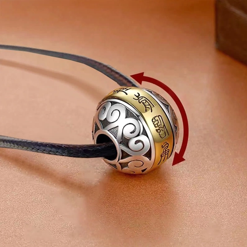 Rotatable Buddhist amulet pendant with dark blue genuine leather cord, close-up side view of engraved two-tone copper mantra design