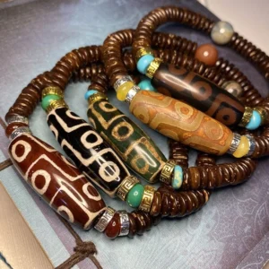 collection of handmade nine-eye dzi bead bracelets in multiple colors featuring agate beads with traditional eye patterns and natural gemstone accents