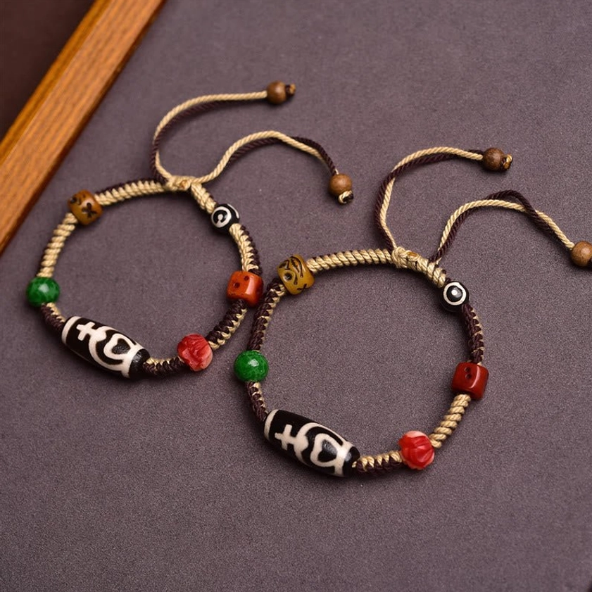 Two matching nine-eye dzi bead bracelets for couples or collectors, identical designs with hand-knotted adjustable closures