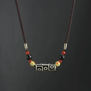 Nine-Eye Dzi Bead Buddhist necklace pendant in black and white natural agate with adjustable woven cord and gold metal accents, front flat view
