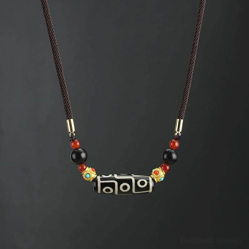 Nine-Eye Dzi Bead Buddhist necklace pendant in black and white natural agate with adjustable woven cord and gold metal accents, front flat view